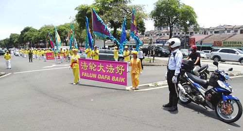 '图6：马来西亚法轮功学员来到雪兰莪州班丹英达（Pandan Indah）举办庆中秋游行活动，交通警察和自愿警卫队前来提供协助，为法轮功游行队伍开路。'