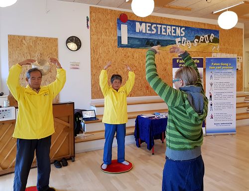 法轮功学员参加奥尔堡的自由学校健康展，游客现场学功。