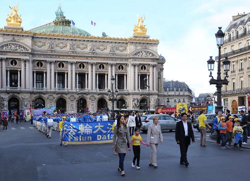 '图3：奥斯塔丽女士全程参加了法轮功学员的集会与游行，并一直走在游行队伍的最前面。图为游行队伍经过巴黎歌剧院（Opéra Garnier）。'
