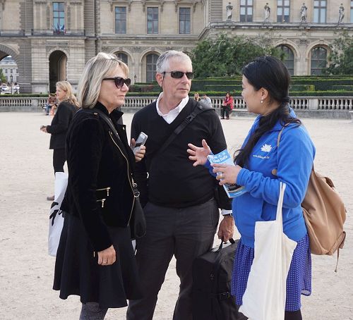 '图4：游行在卢浮宫广场结束后，这对夫妇仍在向法轮功学员询问真相。'