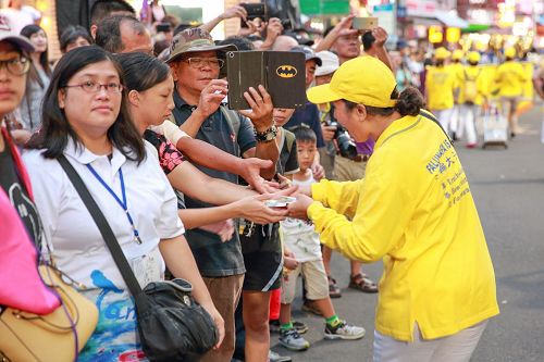 '图7：群众向法轮大法学员抢着要法轮功真相资料和莲花书签。'