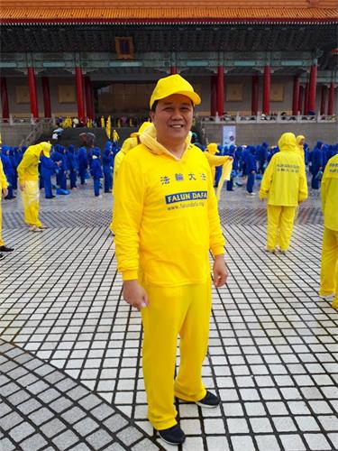 '修鍊心得交流會前夕，陳昱熾參加在台北自由廣場舉行的大型排字及集體煉功活動。'