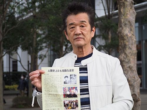 '图4：日本民众小高先生手持法轮功真相报纸表示期待和平'