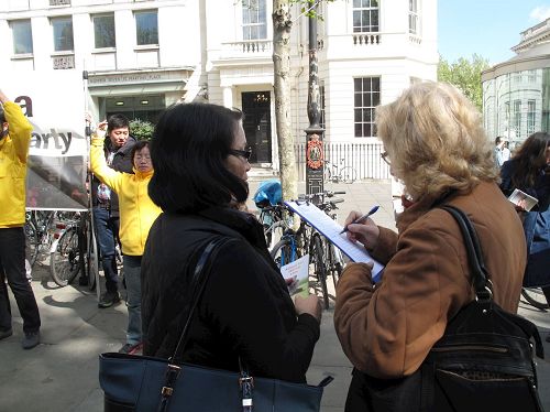 '图16：二零一七年四月二十二日，退休教师约翰逊女士在圣马丁广场被法轮功学员的平和抗议所吸引，了解真相后签名反迫害'