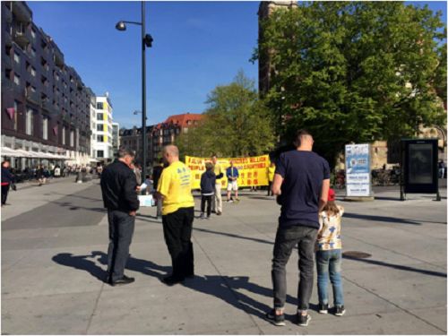 瑞典学员向路过的行人发放传单，并介绍法轮大法。