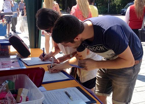 '图4～5：在雷根斯堡城市节上，民众签名声援法轮功学员反迫害。'