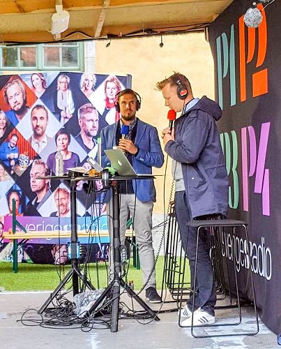 '圖2：七月六日上午法輪功學員代表圖比亞斯（左）在直播現場，接受了瑞典國家電台（Sveriges Radio）的時事與新聞頻道P1記者的採訪'