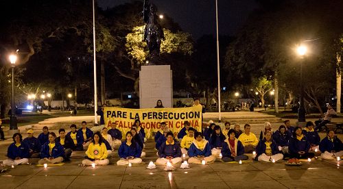 图3-4：秘鲁法轮功学员们点起了烛光，悼念被中共迫害致死的中国大陆<span class='voca' kid='59'>同修</span>，并呼吁早日制止迫害。