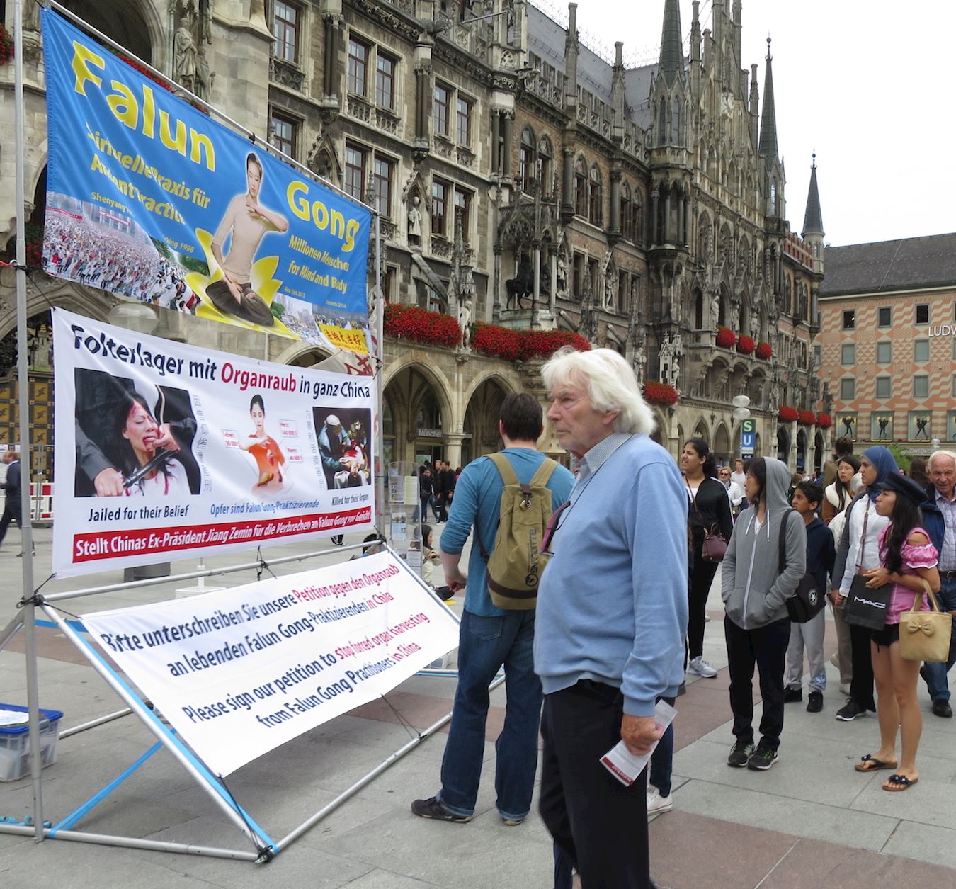 2017年8月12日,德國南部名城慕尼黑(Munich)部分法輪功學員在市政廳前瑪琳廣場(Marienplatz)設立法輪功真相展位。有人當場跟法輪功學員學煉功法,還有人馬上就到對面的書店訂購《轉法輪》書籍。民眾也紛紛加入譴責中共對法輪功學員迫害的行列中,人們在給聯合國人權委員會的請願書上簽名。(明慧網)