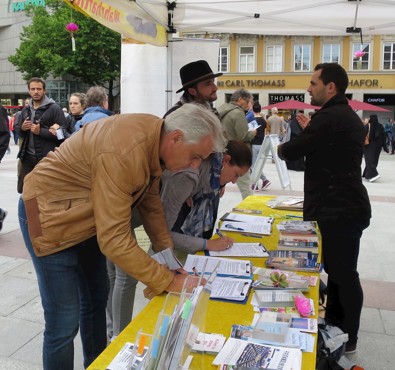 2017年8月12日,德國南部名城慕尼黑(Munich)部分法輪功學員在市政廳前瑪琳廣場(Marienplatz)設立法輪功真相展位。有人當場跟法輪功學員學煉功法,還有人馬上就到對面的書店訂購《轉法輪》書籍。民眾也紛紛加入譴責中共對法輪功學員迫害的行列中,人們在給聯合國人權委員會的請願書上簽名。(明慧網)