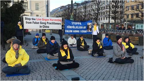 '图1～2：瑞典法轮功学员在哥德堡市中心举办活动，向民众介绍<span class='voca' kid='86'>功法</span>，揭露中共迫害'