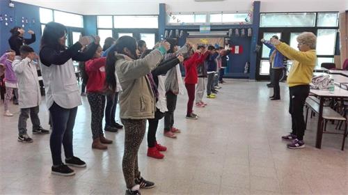 'Figura 1: el 31 de agosto de 2018, los practicantes de Falun Gong en Buenos Aires enseñaron a los niños ejercicios de Falun Gong en una escuela en la ciudad de Sorano.  '