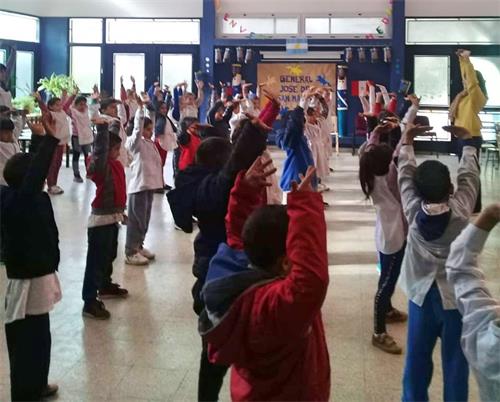 'Figuras 2 a 3: el 13 de julio de 2018, los practicantes de Falun Gong en Buenos Aires enseñaron a los niños ejercicios de Falun Gong en una escuela en la ciudad de Sorano.  '