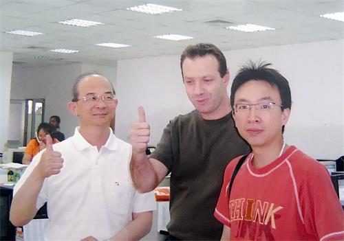 '图3：黄士坤（左）修炼大法之后，如期于二零零四年在赖索托建厂时，与来访的美国客户的合照。'