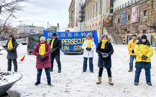 '图1：法轮功学员们冒着严寒在斯德哥尔摩市中心皇宫旁的钱币广场上举办讲真相活动。'