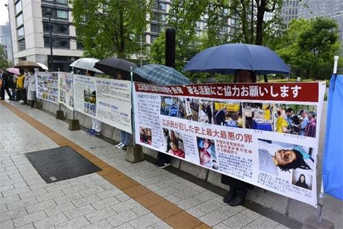 '法轮功学员在日本众议院会馆前呼吁制止中共迫害。'