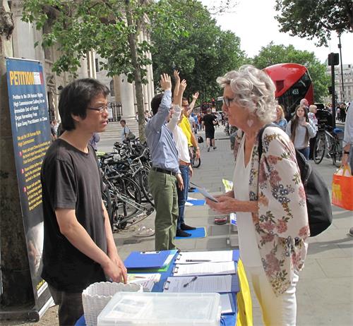 图10：二零一八年六月十二日，在伦敦圣马丁广场，想学功的苏珊（Susan）向法轮功学员深入了解真相。
