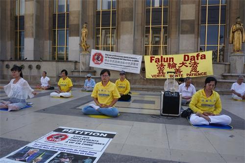 '图5：8月19日，巴黎部份法轮功学员在人权广场上炼习第五套功法'