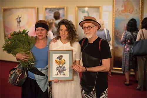 '图4：艺术家雅纳德齐夫（右）向主办者波特瓦（中）赠送了画作'