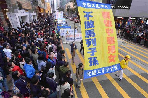 '图13：游行队伍呼吁中国民众抛弃马列邪教，做个堂堂正正的中华儿女。'