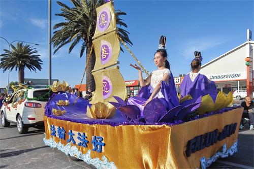 '图3：仙女打扮的学员在花车上展示法轮功功法'