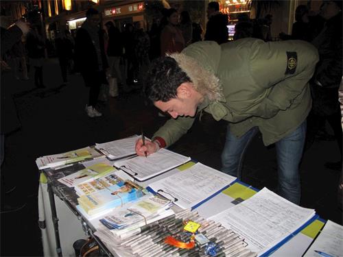 '图5：二零一九年二月十日，来伦敦旅游的意大利青年托尼（Tony）在唐人街尝试炼功并签名反迫害'