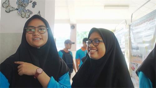 '图13：学生Natashah（左）开心的与大家分享了今早学炼法轮功后，肩膀旧患惊喜得到改善的体会。友人Nabila（右）也为她感到开心。'