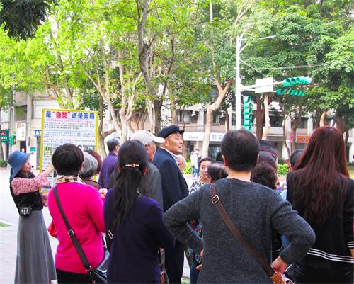 '图3：中国大陆游客眼观展板、耳听法轮功学员讲真相。'