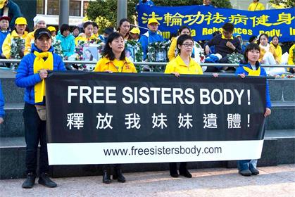 '她的姐姐王易非（右二）手持横幅抗议'