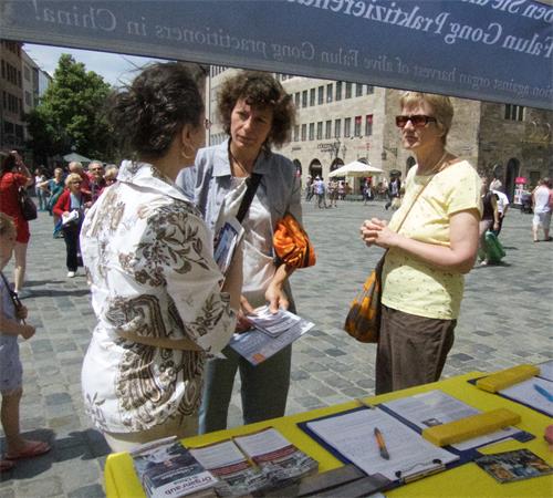 图1～2：二零一九年六月十五日，法轮功学员在纽伦堡（Nürnberg）市中心圣·劳伦斯教堂（St. Lorenz）前举办活动，揭露中共迫害。