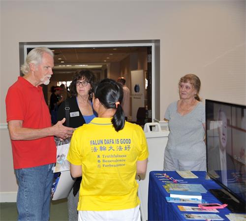 '图2：来自约翰溪市的尼德夫妇在亚特兰大约翰溪市健康博览会向法轮功学员了解法轮大法。'