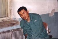 '中新网2002年4月1日的图片显示：关押的房间内血迹斑斑，刘成军显然已无力保持自然坐'