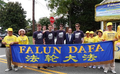 6：美国马里兰州联邦众议员拉斯金（Jamie Raskin)（左七）在游行终点处与法轮功学员合影。