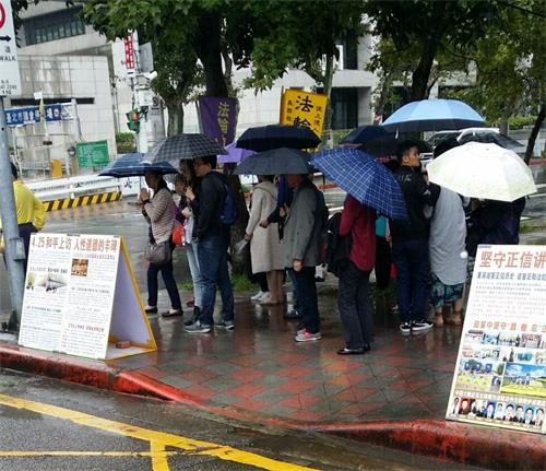 '图1～2：法轮功学员常年坚持在台北国父纪念馆摆展板，讲真相，风雨无阻，帮助很多游客了解了法轮功真相。'