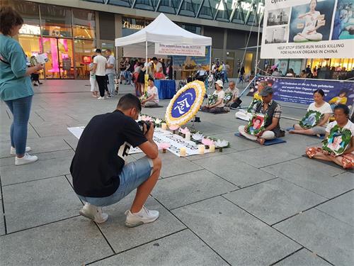 '图1～2：2019年8月31日，法轮功学员在法兰克福商业大道上举办烛光守夜活动，引来路人的关注'