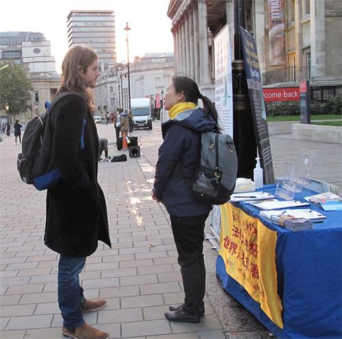 '图10：二零二零年十月十日，英格兰人查理·卡勒（Charle Calle）在伦敦特拉法加广场与法轮功学员交谈了解真相'