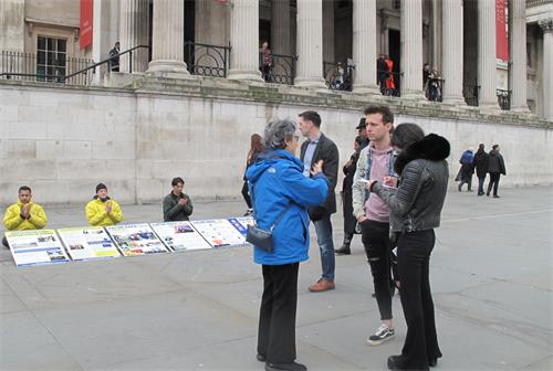 图7：二零二零年三月七日，在特拉法加广场，英国苏塞克斯（Sussex）一家国际学校的老师丹（Dan）正在聆听学员讲述真相。