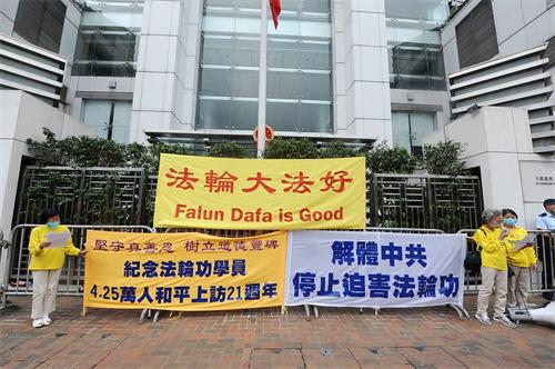 '图1：香港法轮功学员四月二十五日“四人为一组”的形式到中联办外抗议。'