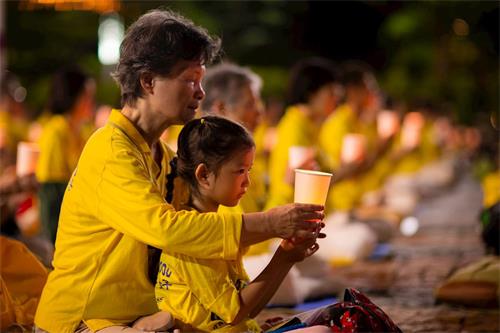 '图1～3：法轮功学员在台北市政府广场前举办反迫害21周年烛光悼念活动。'