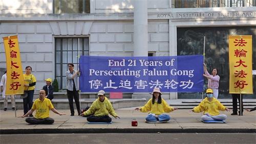 '图1～2：二零二零年七月二十日， 英国法轮功学员在伦敦中共使馆前集体炼功反迫害'