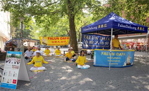 '图1：二零二零年八月一日，德国法轮功学员在慕尼黑红十字广场（Rotkreuzplatz）举办了信息日活动。图为学员在展示功法。'