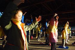 图：法轮功学员和小弟子在日出的阿里山峰顶的祝山，迎着第一道晨曦炼功弘法。