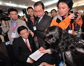 图：中共北京副市长吉林在数百人的会场上，对递到眼前的诉状，一脸愕然