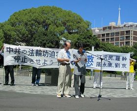 日本法轮大法学会代表鹤园雅章（左）在集会上发言