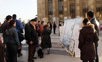 埃菲尔铁塔旁的人权广场上，人们在观看法轮功真相展板
