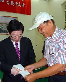 中共宗教局长王作安（左）在拜访台北清真寺后，收到法轮功学员（右）送的诉状，王认为是礼物，道谢收下。