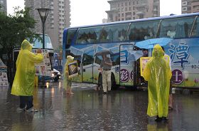 六月二十六日下午受到米雷台风外围环流影响，下起了大雨。法轮功学员们一个也没离开，穿起雨衣继续拿展板讲真相。