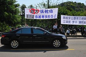 “你被刑事控告了”——安徽省省长王三运四月二十日上午至桃园县桃园铭传大学时，车队在校园路前看到法轮功学员的抗议横幅