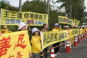 台南市议员曾秀娟（左三）声援法轮功，一起拉横幅对王三运大声呼口号。