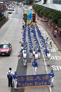 '在天国乐团领头下，游行队伍在港岛的街道上前进。'